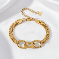 Goldenes Armband aus Edelstahl mit doppelter Gliederstruktur auf weißem Stoff