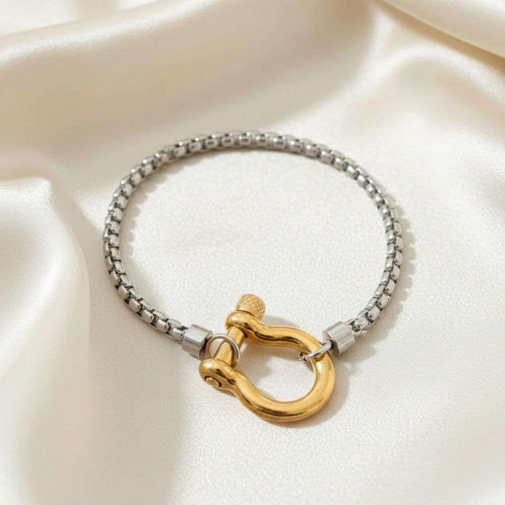 Edelstahl-Armband mit goldener U-Schackle an einem Handgelenk