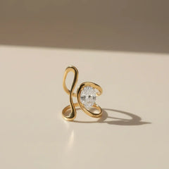 Skulpturaler goldener Damenring aus Edelstahl mit großem Zirkonia-Stein auf hellem Hintergrund