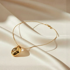 Goldkette für Damen mit modernem Skulpturanhänger aus Edelstahl, 18K vergoldet, auf Seide