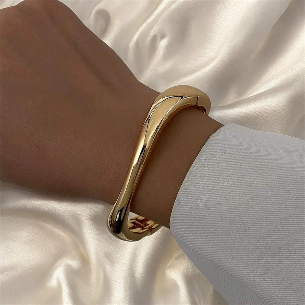 Zarter goldener Armreif aus Edelstahl, 18 K vergoldet, handpoliert und minimalistisch geformt – LOÉAR Schmuck.