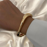 Zarter goldener Armreif aus Edelstahl, 18 K vergoldet, handpoliert und minimalistisch geformt – LOÉAR Schmuck.