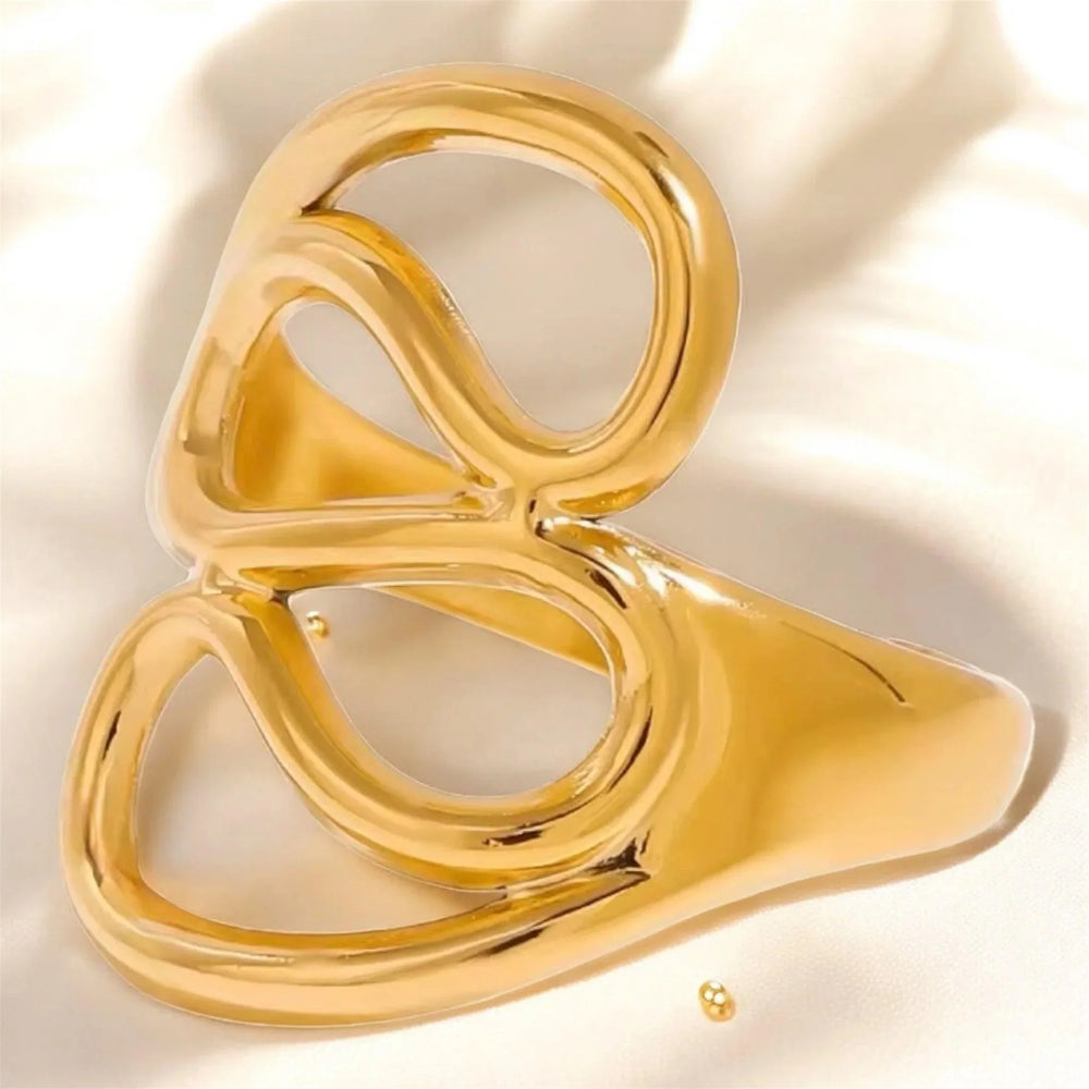 Skulpturaler Damenring aus 18K vergoldetem Edelstahl, modern und zeitlos, auf hellem Stoff