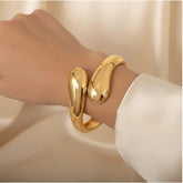 Goldener offener Armreif mit skulpturalem Design, 18 K vergoldet, getragen am Handgelenk – LOÉAR Schmuck.