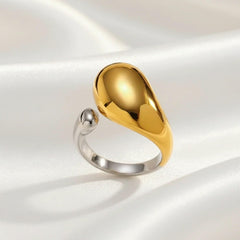 Offener Ring in Bicolor aus Edelstahl mit glänzender goldener Tropfenform und silbernem Band – moderner, minimalistischer Designring von LOÉAR.“