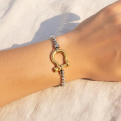 Edelstahl-Armband mit goldener U-Schackle an einem Handgelenk