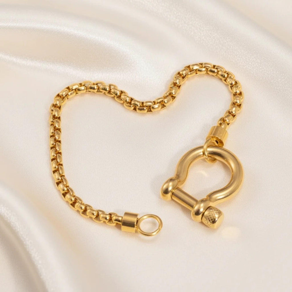 Vergoldetes Gliederarmband mit großem Schraubverschluss auf hellem Hintergrund