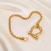 Vergoldetes Gliederarmband mit großem Schraubverschluss auf hellem Hintergrund