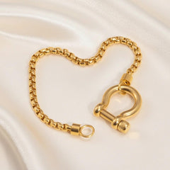 Vergoldetes Gliederarmband mit großem Schraubverschluss auf hellem Hintergrund