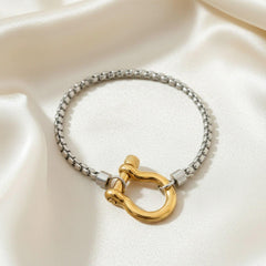 Edelstahl-Armband mit goldener U-Schackle an einem Handgelenk