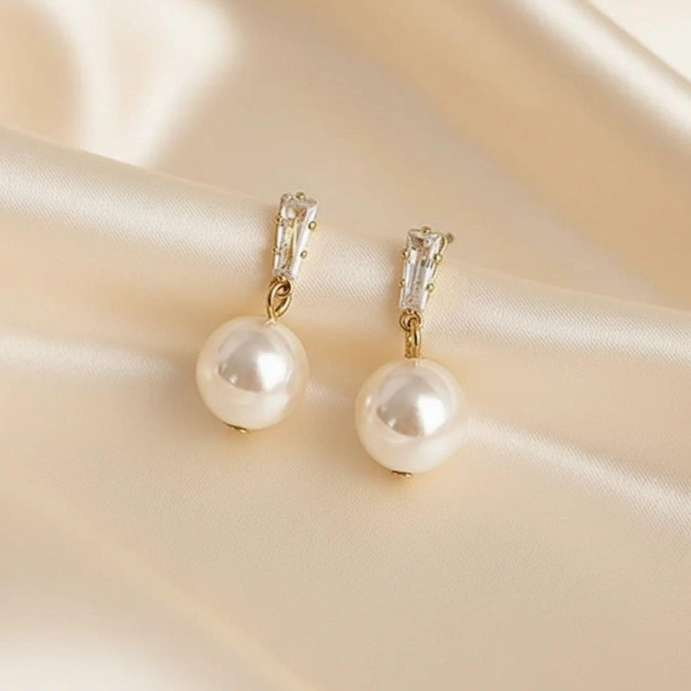 Goldfarbene Perlen-Drop-Ohrringe mit glänzender Perle – eleganter Schmuckstil.