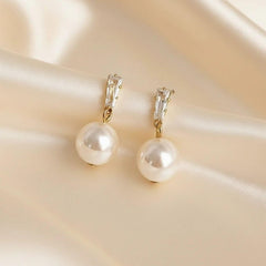 Goldfarbene Perlen-Drop-Ohrringe mit glänzender Perle – eleganter Schmuckstil.