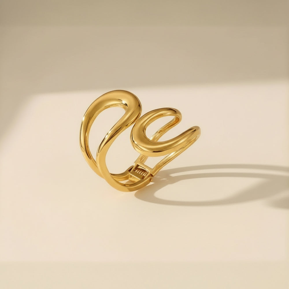 Vergoldeter Armreif mit skulpturalem, geschwungenem Design – modernes, glänzendes Statement-Schmuckstück aus Edelstahl von LOÉAR.