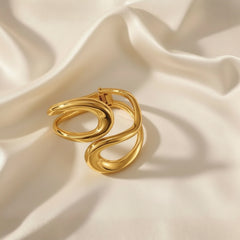 Vergoldeter Armreif mit skulpturalem, geschwungenem Design – modernes, glänzendes Statement-Schmuckstück aus Edelstahl von LOÉAR.