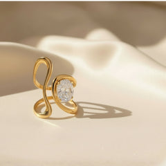 Vergoldeter Designring mit geschwungener, offener Form und funkelndem ovalem Kristall – moderner Statement-Ring aus Edelstahl von LOÉAR.