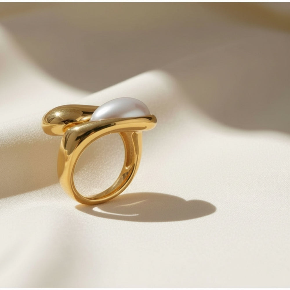 Vergoldeter Ring mit weißer Perle in organischer, fließender Fassung – elegantes, modernes Schmuckdesign aus Edelstahl von LOÉAR.
