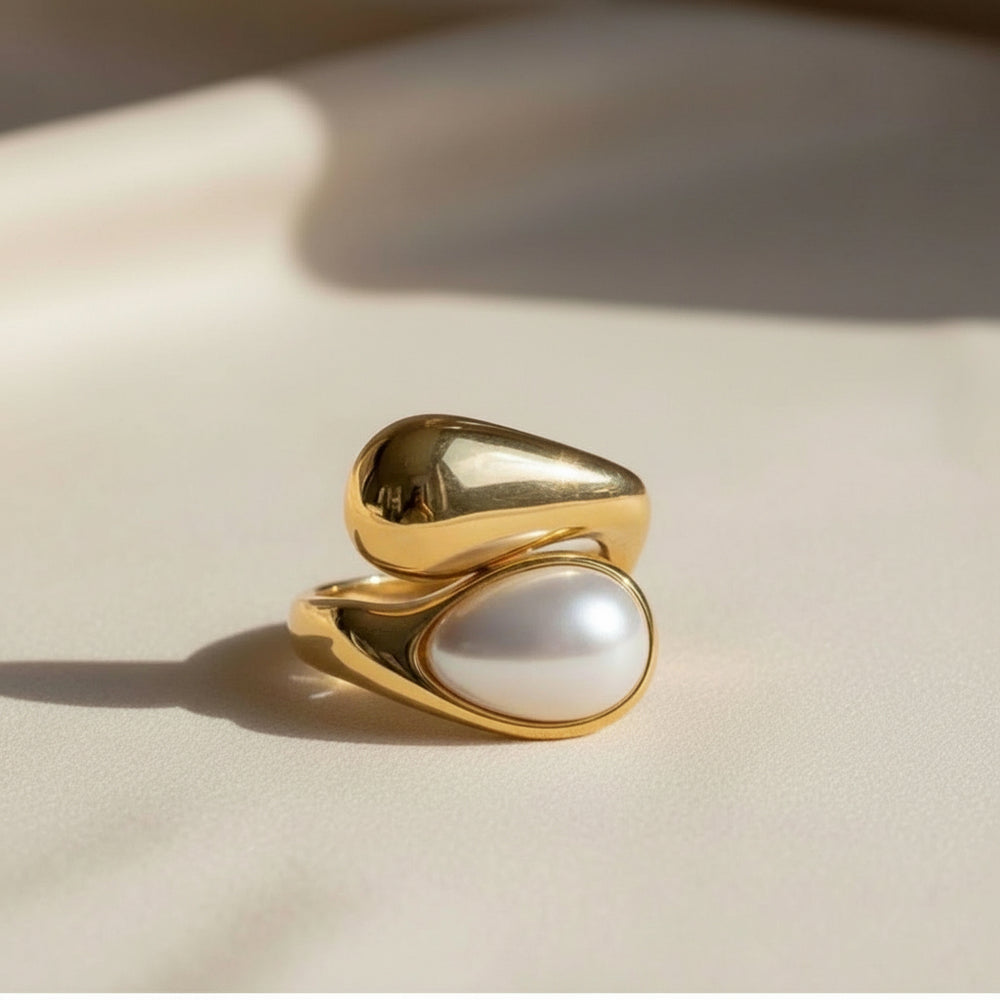 Vergoldeter Ring mit weißer Perle in organischer, fließender Fassung – elegantes, modernes Schmuckdesign aus Edelstahl von LOÉAR.