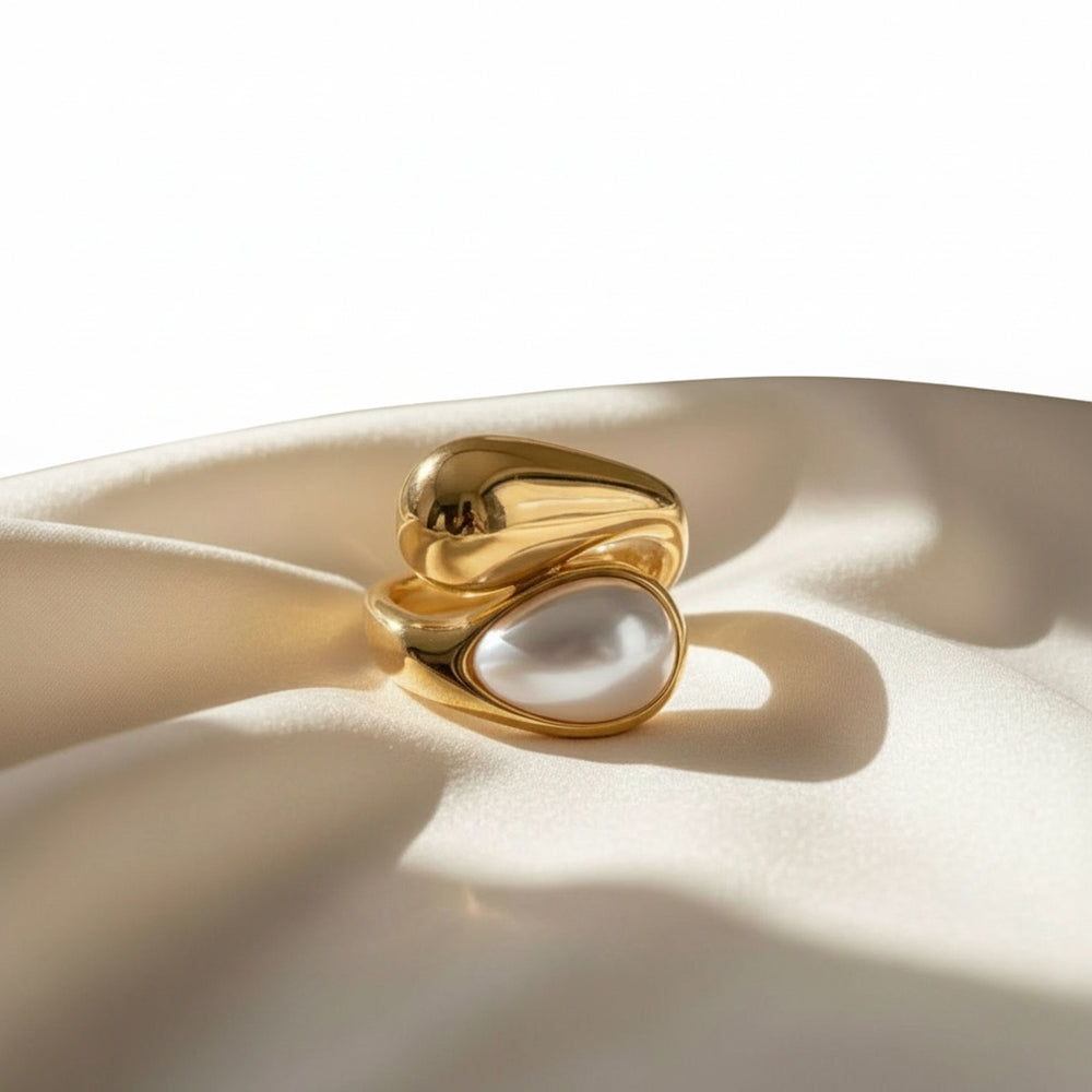 Vergoldeter Ring mit weißer Perle in organischer, fließender Fassung – elegantes, modernes Schmuckdesign aus Edelstahl von LOÉAR.