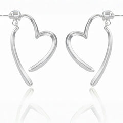 Silberne, offen geformte Herz-Ohrringe mit fließender Linienführung auf hellem Hintergrund.