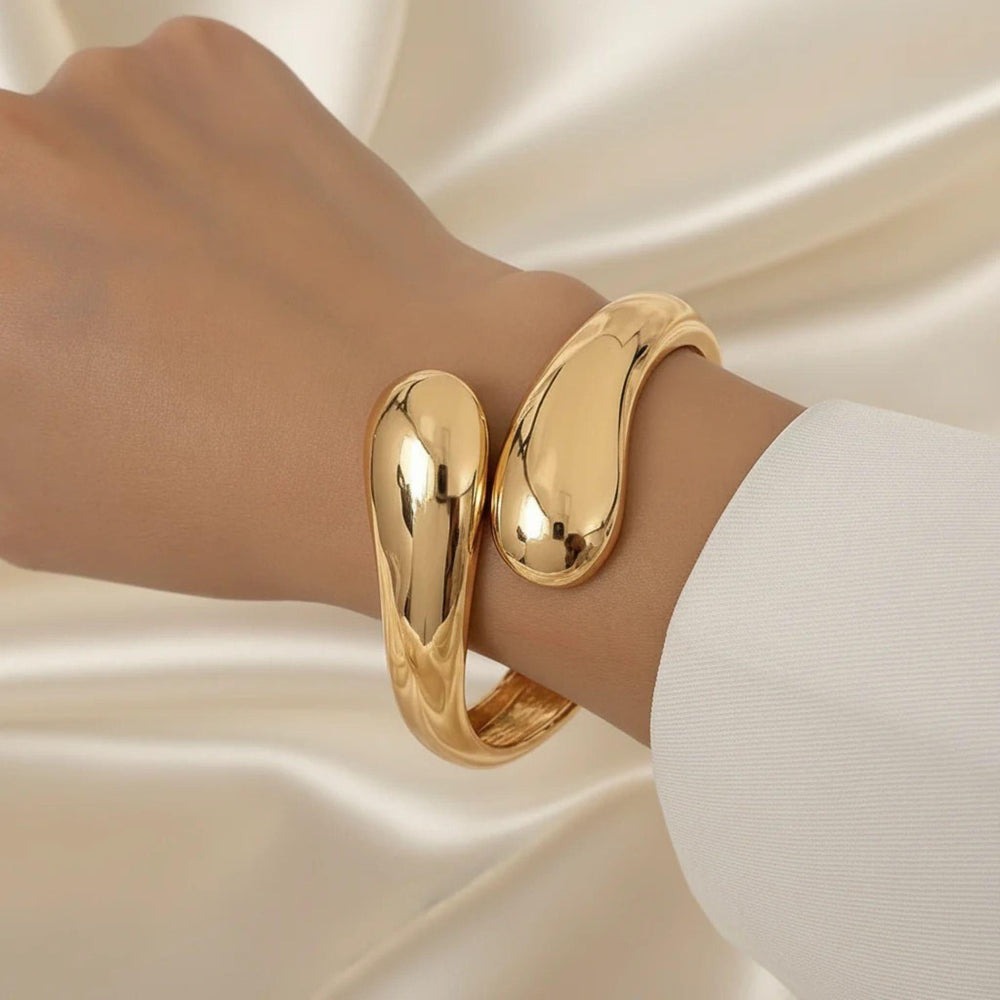 Goldener offener Armreif mit skulpturalem Design, 18 K vergoldet, getragen am Handgelenk – LOÉAR Schmuck.