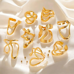 Eleganter goldener Armreif mit wellenförmigem, offenem Design auf glänzendem Seidentuch – moderner Statement-Schmuck von LOÉAR.