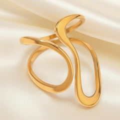 Eleganter goldener Armreif mit wellenförmigem, offenem Design auf glänzendem Seidentuch – moderner Statement-Schmuck von LOÉAR.